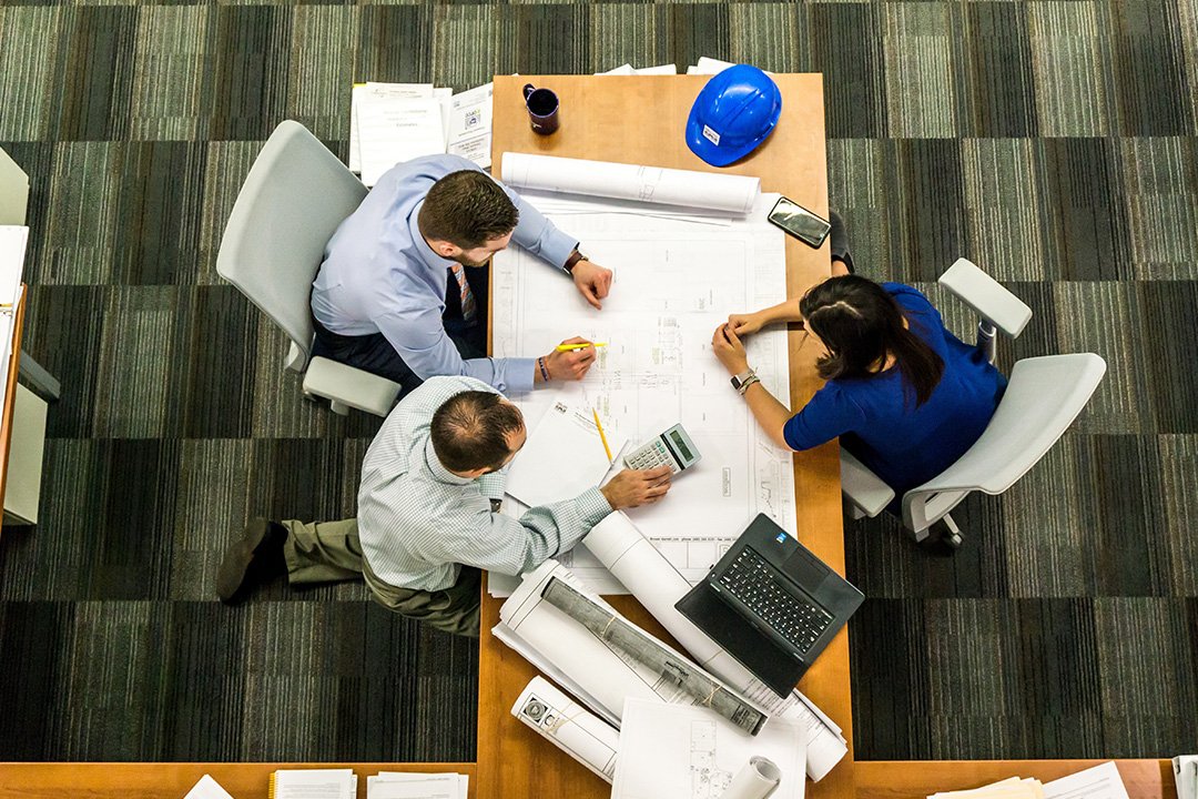 Three business people planning out strategy at table