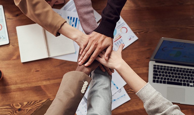 Team members putting hands in together